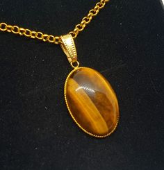 Large Oval semi-precious South African Golden Tiger's eye pendant necklace, gold-plated finish necklace. This is a beautiful statement necklace made with a semi-precious South African Golden Tiger's eye stone.  The pendant necklace is supplied on either a gold plated chain or colour-coordinated faux leather thong (45 - 50cm / 18 - 20" ), PLEASE STATE AT CHECKOUT.  It is made using a stunning 25mm x 18mm oval stone to create a beautiful statement necklace.  The pendant setting is finished in a go Statement Gemstone Necklace, Tiger Necklace, Eye Pendant Necklace, Golden Tiger, Eye Pendant, Stone Pendant Necklace, Tiger Eye Stone, Necklace Statement, Eye Stone