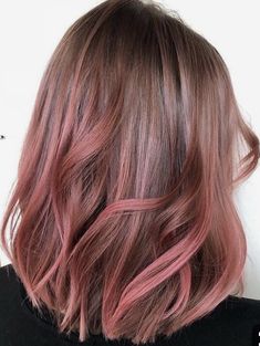 the back of a woman's head with pink hair and long wavy bobs