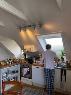 a person standing in a kitchen next to an open window