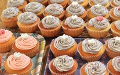 cupcakes with frosting and sprinkles sitting on trays