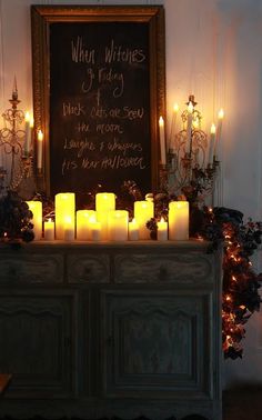 a chalkboard with lit candles on it in front of a dresser