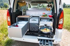 the back end of a van with an open trunk and food trays in it