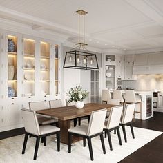 the dining room table is surrounded by white chairs and built - in bookcases