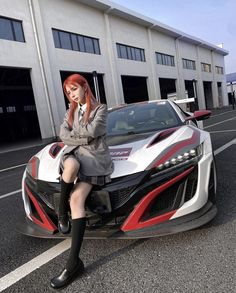 a woman sitting on top of a sports car