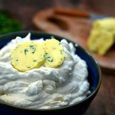 a bowl filled with whipped cream and topped with two pieces of butter