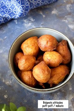 a bowl filled with fried food sitting on top of a table next to a blue cloth