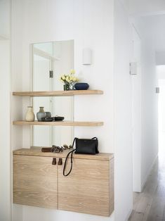 there is a purse and some shoes on the shelf next to the mirror in this room