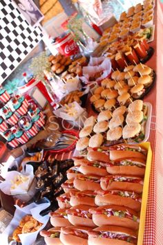 many hotdogs and other food items on a table