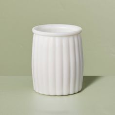 a white vase sitting on top of a table