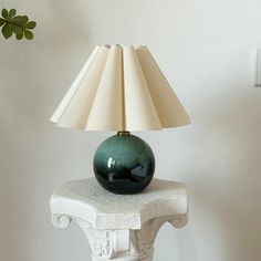 a green lamp sitting on top of a white table