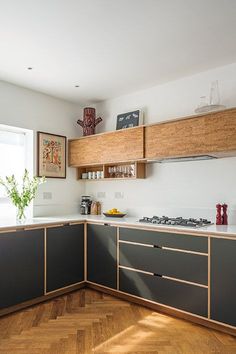 a kitchen with wooden floors and gray cabinets