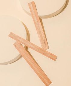 three pieces of wood sitting next to each other on top of a white tablecloth