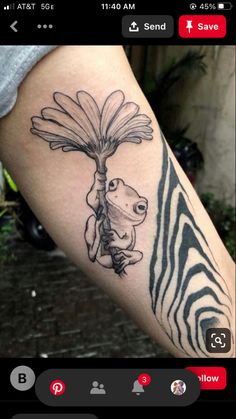 a person with a tattoo on their arm holding a flower and a zebra in the background