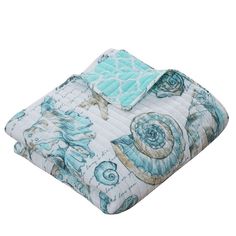 a blue and white comforter with seashells printed on it's side