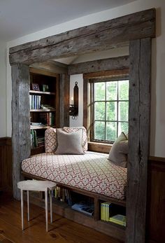 a window seat in the corner of a room with bookshelves on either side