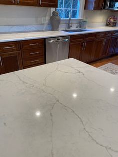 a kitchen with marble counter tops and wooden cabinets