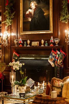 a living room decorated for christmas with stockings and candles on the fireplace mantels