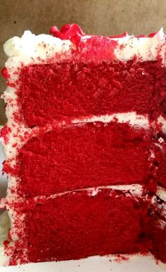 a slice of red velvet cake with white frosting