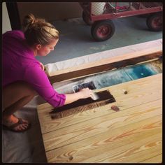 a woman is sanding up some wood