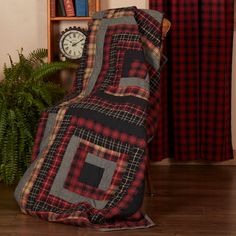 a blanket sitting on top of a wooden floor next to a clock and book shelf