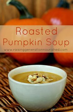 roasted pumpkin soup in a white bowl on a wicker place mat next to two orange pumpkins