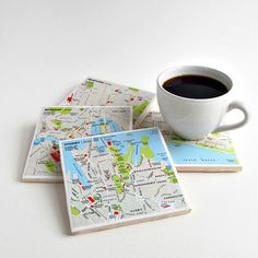 three coasters with maps on them and a cup of coffee in the middle one