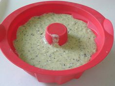 a red food processor filled with batter on top of a table