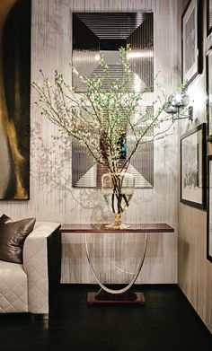 a vase with some flowers in it sitting on a table next to a white couch