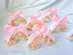 small candy candies with pink bows are in plastic bags on a white tablecloth