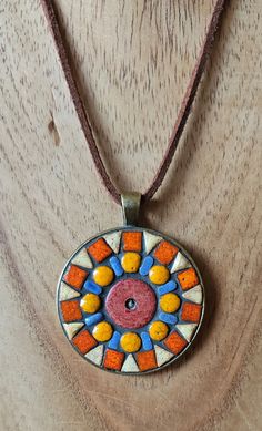 a necklace with an orange, yellow and blue design on it