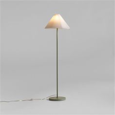 a floor lamp with a white shade on it's base and a cord plugged into the bulb