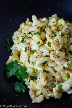 macaroni and cheese with parsley in a black bowl