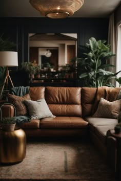 a living room with brown leather couches and potted plants on the table in front of it