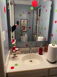 a bathroom sink with polka dot wallpaper on the walls