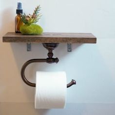 a toilet paper roll is hanging on the wall next to a towel rack with two rolls of toilet paper