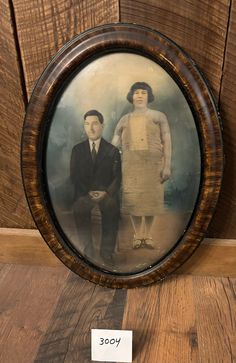 an old photo of two people sitting next to each other on a wooden table with a price tag