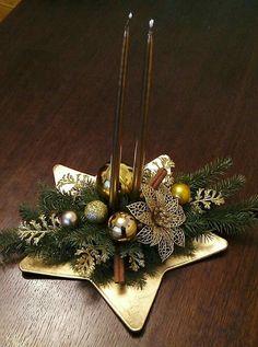 a star shaped centerpiece with candles and ornaments on it's side sitting on a wooden table