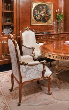 an elegant dining room with wood paneling and white chairs in front of a wooden table