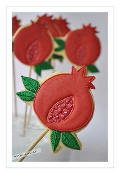 decorated cookies with pomegranates and leaves on sticks