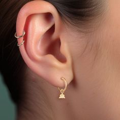 a woman's ear with two small hoops attached to it