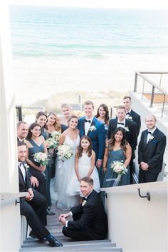 a group of people that are standing in front of each other on some steps near the beach