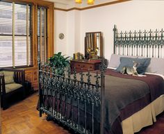 a bed room with a neatly made bed and wooden floors