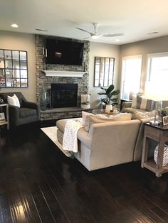 a living room filled with furniture and a flat screen tv mounted on the wall above a fireplace