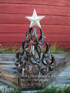 a christmas tree made out of horseshoes with a white star on top and the words twisted wire horse shoe decor