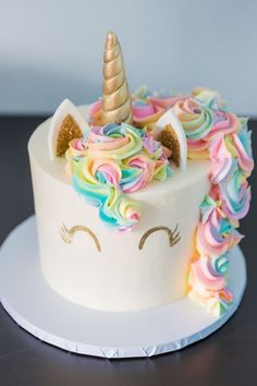 there is a cake decorated with unicorns and rainbow icing