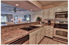 a kitchen with granite counter tops and white cabinets