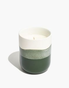 a white and green candle sitting on top of a table