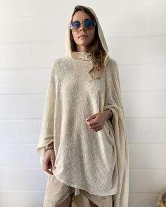 "Off White Knit Cotton Hooded Cape. Cowl Neck Hoodie. Poncho Style. This gorgeous soft tunic is lovingly handmade from an up-cycled cotton blend. It is a part of the collection \"Ceremony White\" - a collection of dresses and pants created specifically for your ceremony journeys, kundalini yoga, sound baths and mediation. Inspired by silent mediation and love for comfortable wear. Material: Up-cycled knit cotton. Very soft, light weight and flowing. Size: One size Overall Length: about 42 in. Ov Cozy Hooded Soft Knit Sweater, Oversized Soft Knit Hoodie, Oversized Knitted Hoodie Sweater, Oversized Winter Poncho For Loungewear, Long Sleeve Poncho For Spring, Long Sleeve Poncho For Spring In One Size, One Size Long Sleeve Poncho For Spring, Oversized Knit Hoodie, Cozy Long Sleeve Poncho For Loungewear