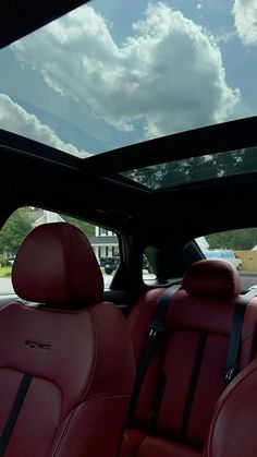 the interior of a car with red leather seats and sky in the back ground area