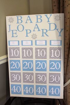 a baby shower sign hanging on the wall next to a window with curtains and drapes